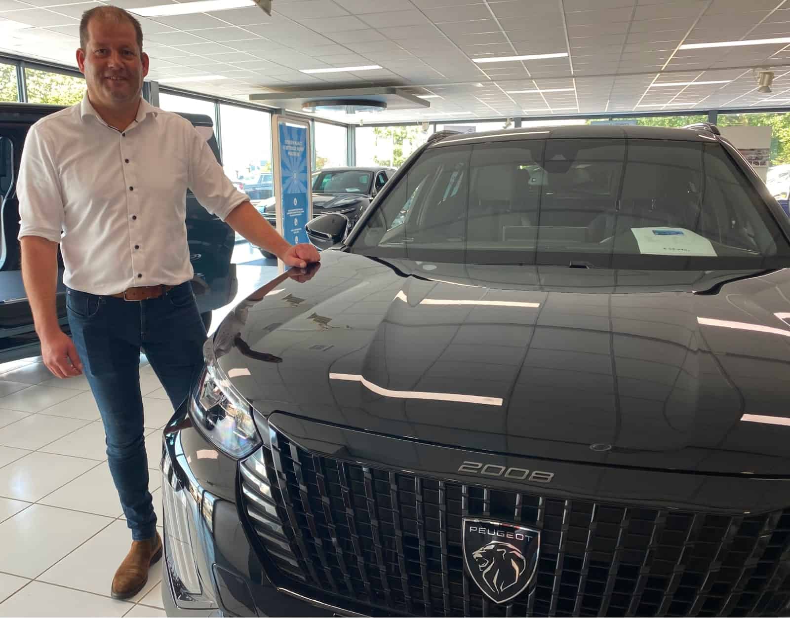 Sebastiaan Stroeve in de showroom van het autobedrijf bij een Peugeot SUV 2008 1-min